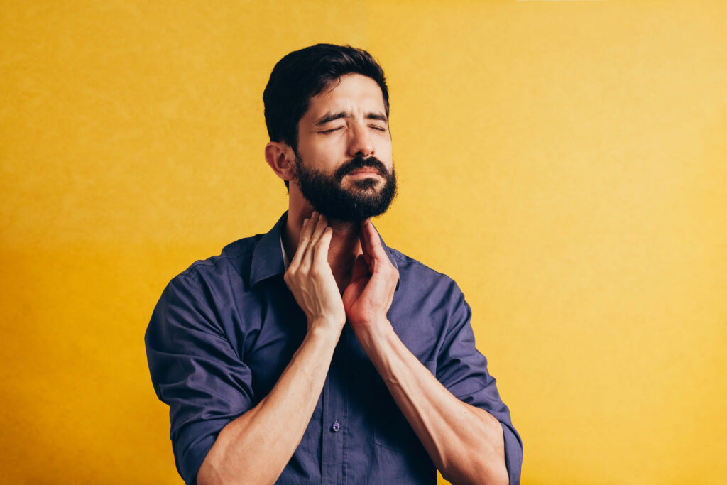 Man massaging his throat