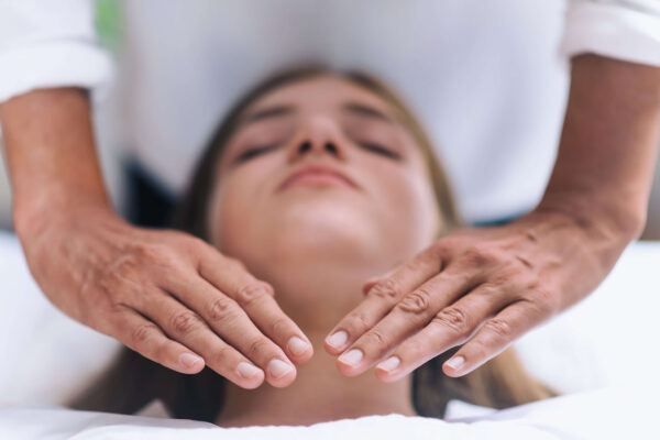 Woman laying down receives a vocal massage