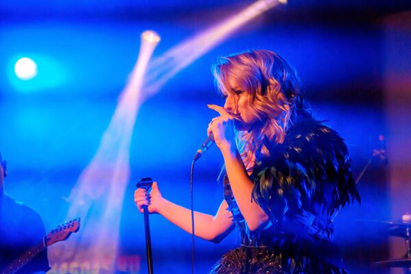 Blonde femal vocal artist on the stage singing