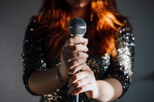 zoomed in photo of a female vocal artist about to sing into a microphone