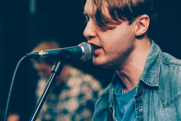 male vocal artist singing into a microphone