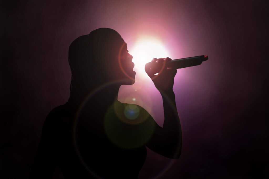 female vocal artist singing into a mic