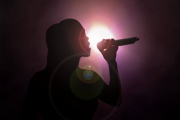 female vocal artist singing into a mic