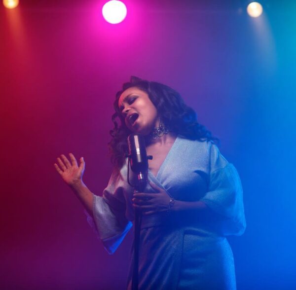 female vocal artist performing in the spotlight